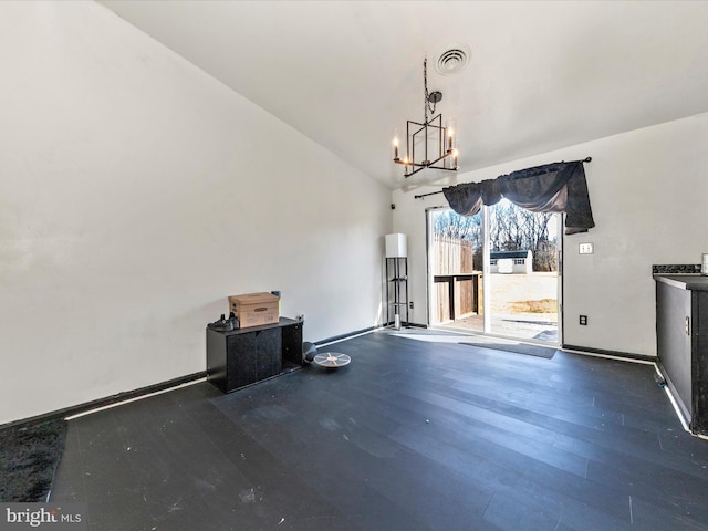 unfurnished dining area with baseboards, visible vents, wood finished floors, vaulted ceiling, and a chandelier