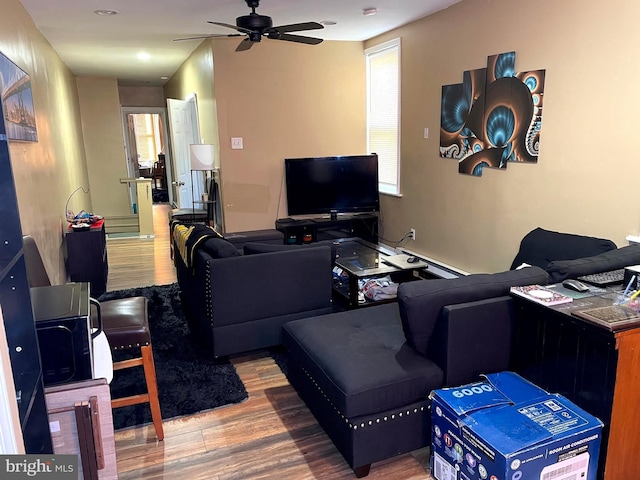 living room featuring hardwood / wood-style flooring, a baseboard radiator, a healthy amount of sunlight, and ceiling fan