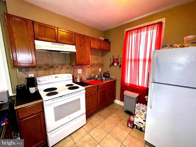 kitchen with light tile patterned flooring, white appliances, and tasteful backsplash