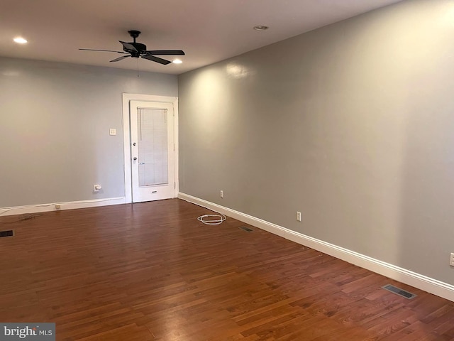 empty room with ceiling fan and dark hardwood / wood-style flooring