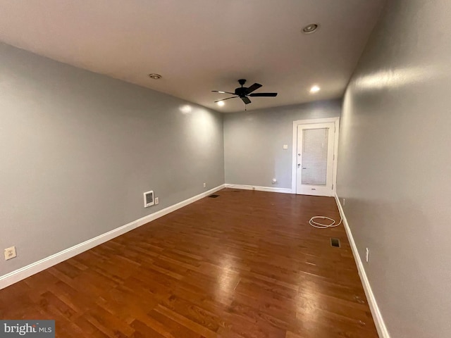 unfurnished room featuring dark wood-type flooring and ceiling fan