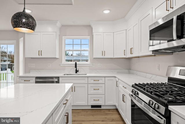 kitchen with stainless steel appliances, sink, hanging light fixtures, and white cabinets