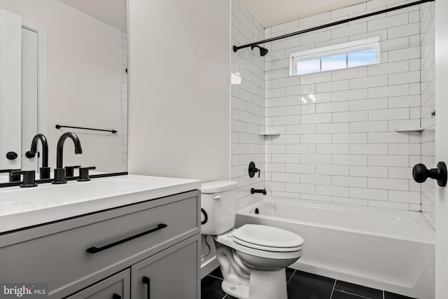 full bathroom with tiled shower / bath, vanity, and toilet