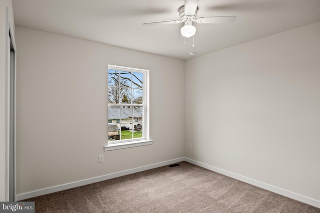 carpeted spare room featuring ceiling fan