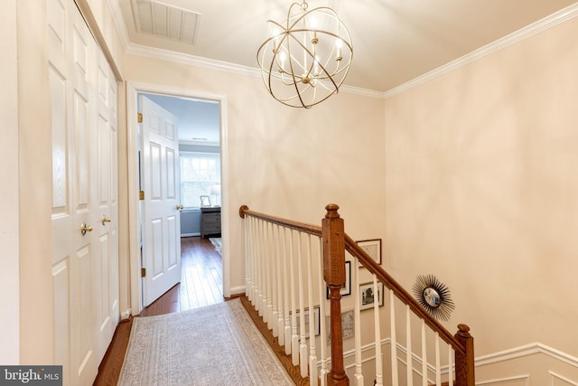 hall featuring crown molding, dark hardwood / wood-style flooring, and an inviting chandelier