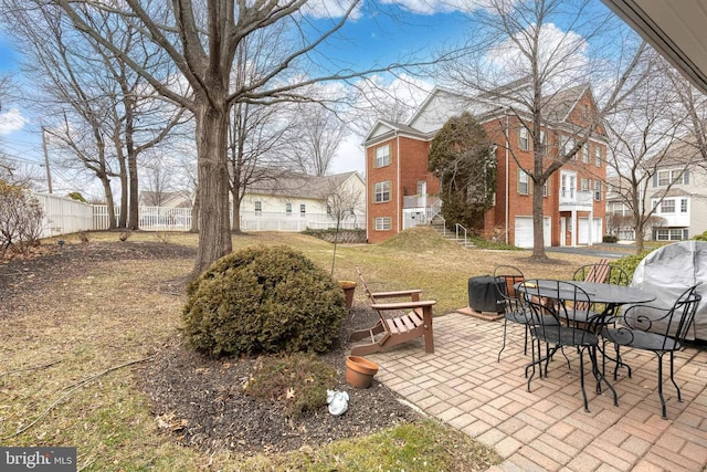 view of yard featuring a garage and a patio area