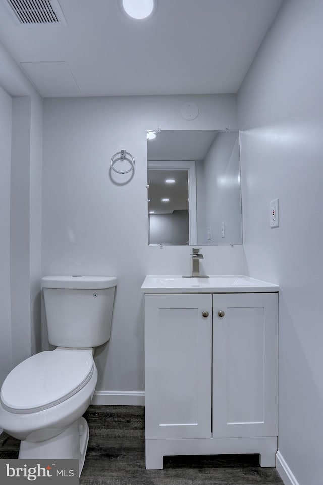 bathroom with vanity, toilet, and hardwood / wood-style floors