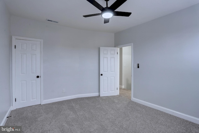 unfurnished room featuring ceiling fan and carpet