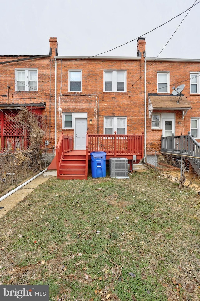 back of property featuring a yard and central AC