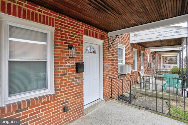 property entrance featuring cooling unit and a porch