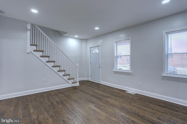 foyer entrance with a healthy amount of sunlight and dark hardwood / wood-style floors