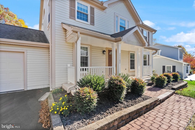 view of front property with a porch and a garage