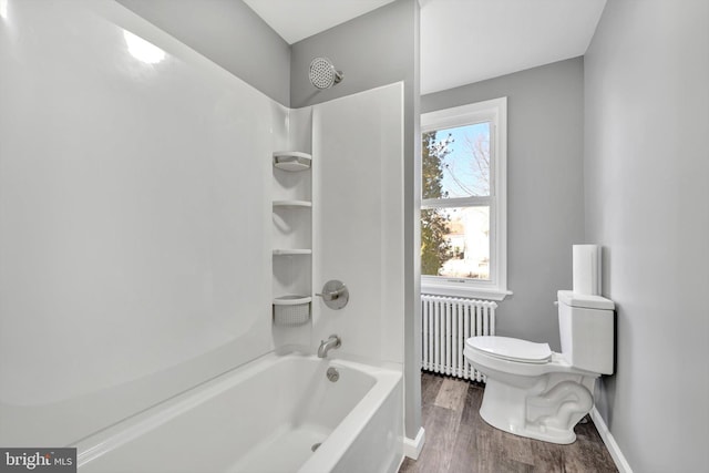 bathroom featuring hardwood / wood-style floors, radiator heating unit, toilet, and washtub / shower combination