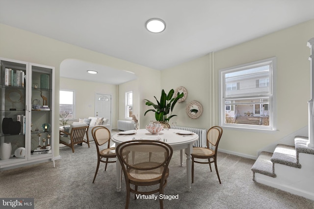 carpeted dining room featuring radiator