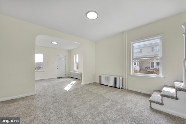 carpeted entrance foyer featuring radiator heating unit