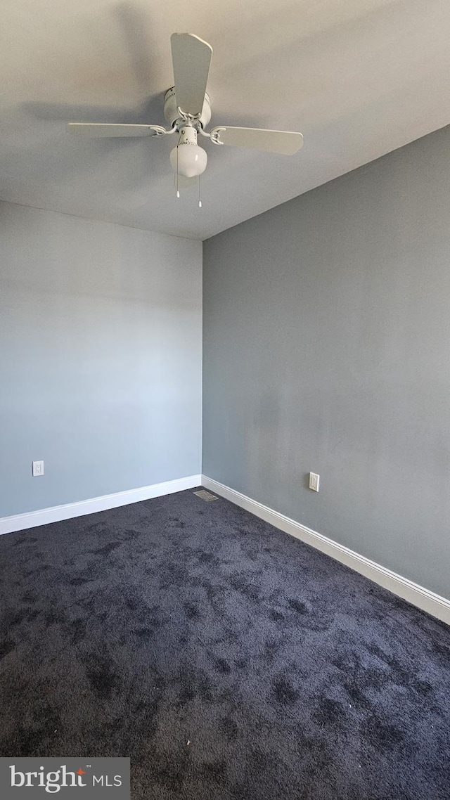 empty room featuring ceiling fan and carpet