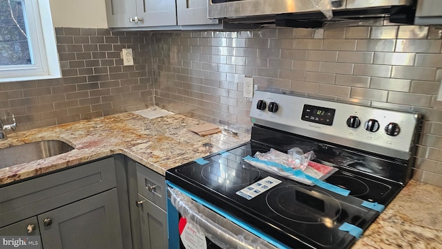 kitchen featuring sink, gray cabinetry, tasteful backsplash, light stone countertops, and stainless steel electric range oven