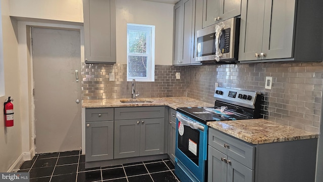 kitchen featuring appliances with stainless steel finishes, sink, and gray cabinetry