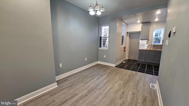 interior space with dark hardwood / wood-style flooring, sink, and a notable chandelier