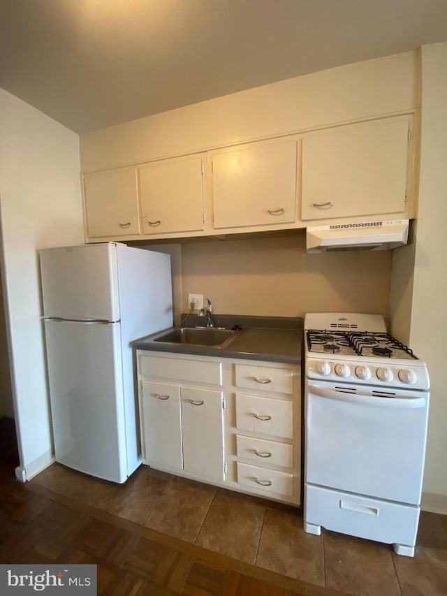 kitchen featuring sink, white appliances, white cabinets, and dark tile patterned flooring