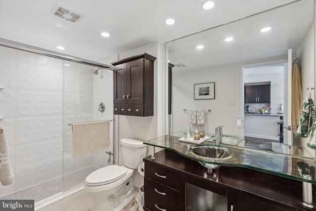 bathroom featuring vanity, toilet, and a shower with door