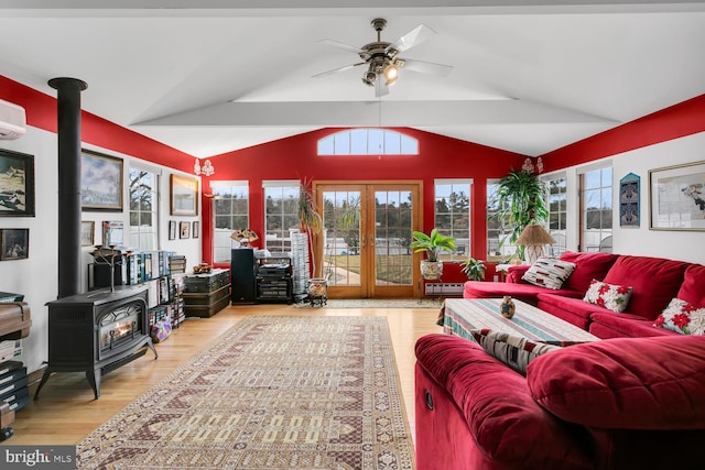 sunroom / solarium with french doors, a wall mounted AC, vaulted ceiling, a wood stove, and ceiling fan