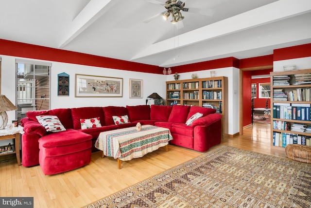 living room featuring lofted ceiling with beams, wood-type flooring, and ceiling fan