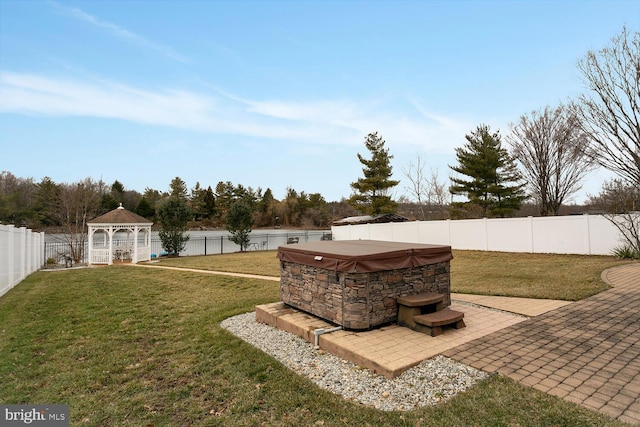 view of yard with a hot tub, a gazebo, and a patio area