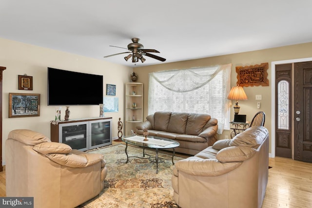 living room with light hardwood / wood-style floors and ceiling fan