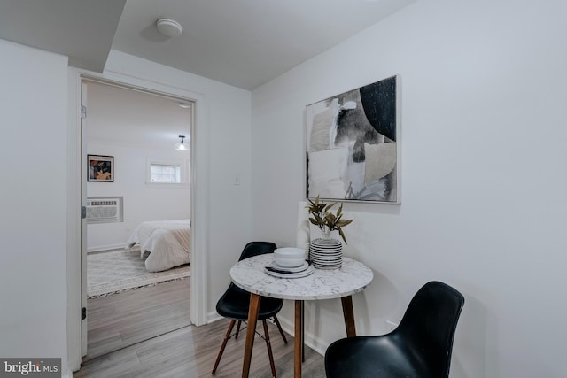 dining room featuring a wall mounted AC and light wood-type flooring