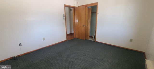 unfurnished room featuring dark carpet