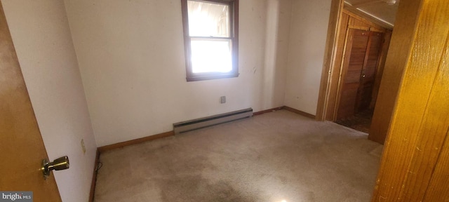 unfurnished room featuring a baseboard radiator and light carpet