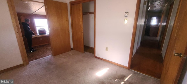 unfurnished bedroom featuring light colored carpet and a closet