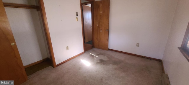 unfurnished bedroom featuring light colored carpet and a closet