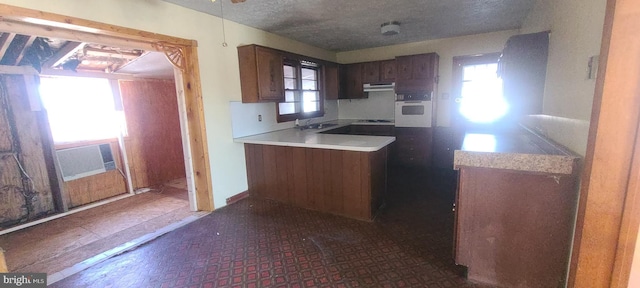 kitchen featuring sink, white oven, and a textured ceiling