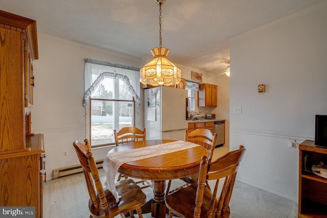 dining area with crown molding, light carpet, and a baseboard heating unit