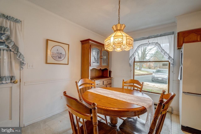 dining room featuring ornamental molding and light carpet