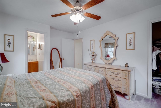 carpeted bedroom with ceiling fan and ensuite bath