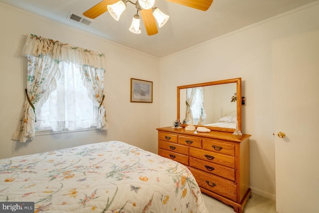 carpeted bedroom with ornamental molding and ceiling fan