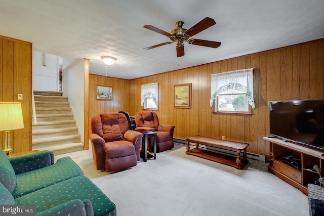 living room with a baseboard radiator, light carpet, ceiling fan, and wood walls