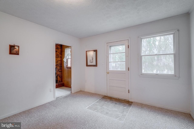 doorway to outside with light carpet and a textured ceiling