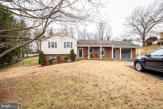 split level home featuring a garage and a front lawn