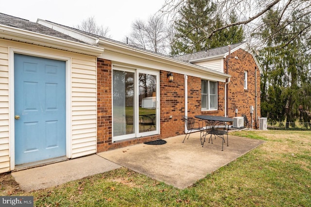 rear view of house with a lawn, central air condition unit, and a patio area