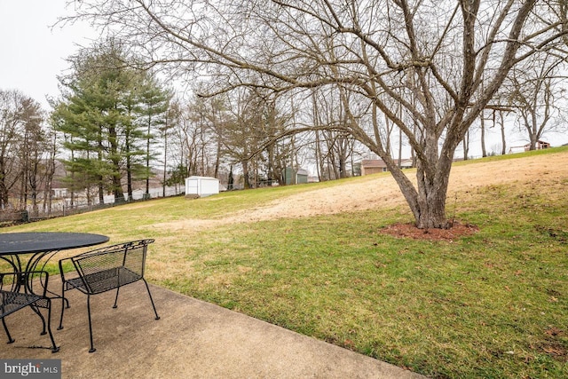 view of yard with a water view, a patio, and a shed