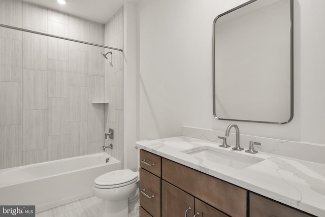 full bathroom with tiled shower / bath, vanity, and toilet