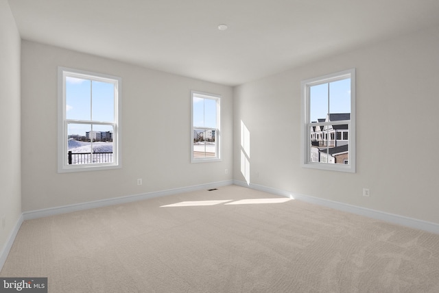 unfurnished room featuring light carpet