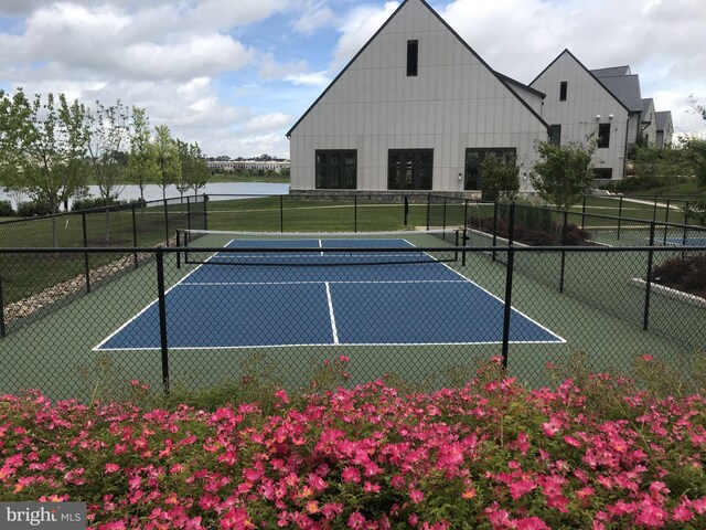 view of tennis court with a water view