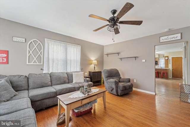 living room with ceiling fan, light hardwood / wood-style floors, and a healthy amount of sunlight