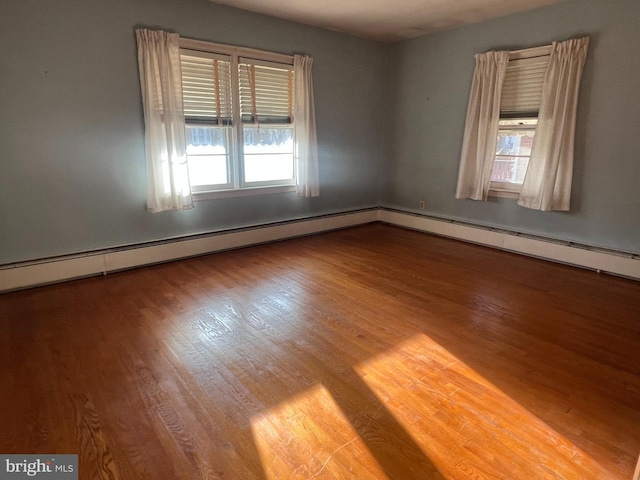 unfurnished room with hardwood / wood-style flooring and a baseboard radiator