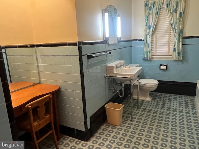 bathroom featuring toilet and tile walls